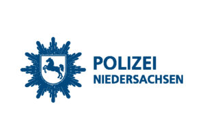 Logo der Polizei Niedersachsen mit einem stilisierten Sternenabzeichen mit einem sich bewegenden Pferdeemblem, das Laufen symbolisiert, auf der linken Seite und dem Schriftzug "POLIZEI NIEDERSACHSEN" in blauer Schrift auf der rechten Seite.